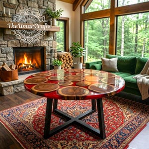 May include: A round coffee table with a red resin top inlaid with wooden slices. The table has a black metal base and sits on a patterned rug. The room features a fireplace and a green sofa.