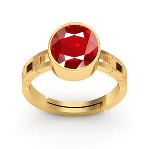 Könnte beinhalten: Ein goldener Ring mit einem großen, runden, facettierten Rubin-Edelstein. Das Band des Rings hat ein geometrisches Design an den Seiten und ist verstellbar. Der Rubin hat eine leuchtend rote Farbe und ist in eine goldene Lünette gefasst.