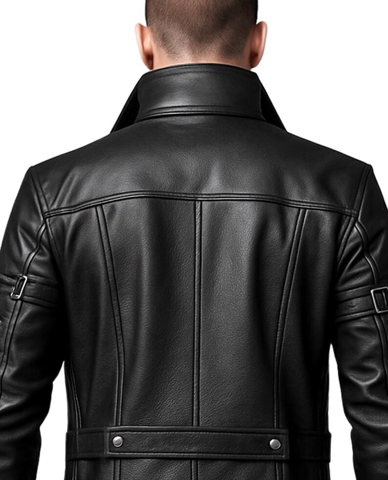 May include: A black leather jacket featuring a high collar, vertical seam detailing on the back, and a horizontal waist strap with two silver-toned metal snaps. The sleeves include adjustable straps with silver-toned metal buckles on each arm.