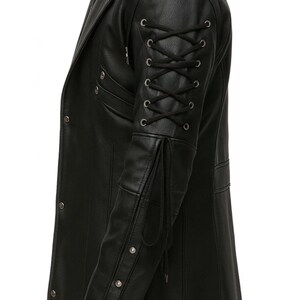 May include: A black jacket featuring a long sleeve with a lace-up detail consisting of black cord threaded through silver-toned metal eyelets. The sleeve also includes a series of silver-toned metal studs along the forearm and a long cord tie.