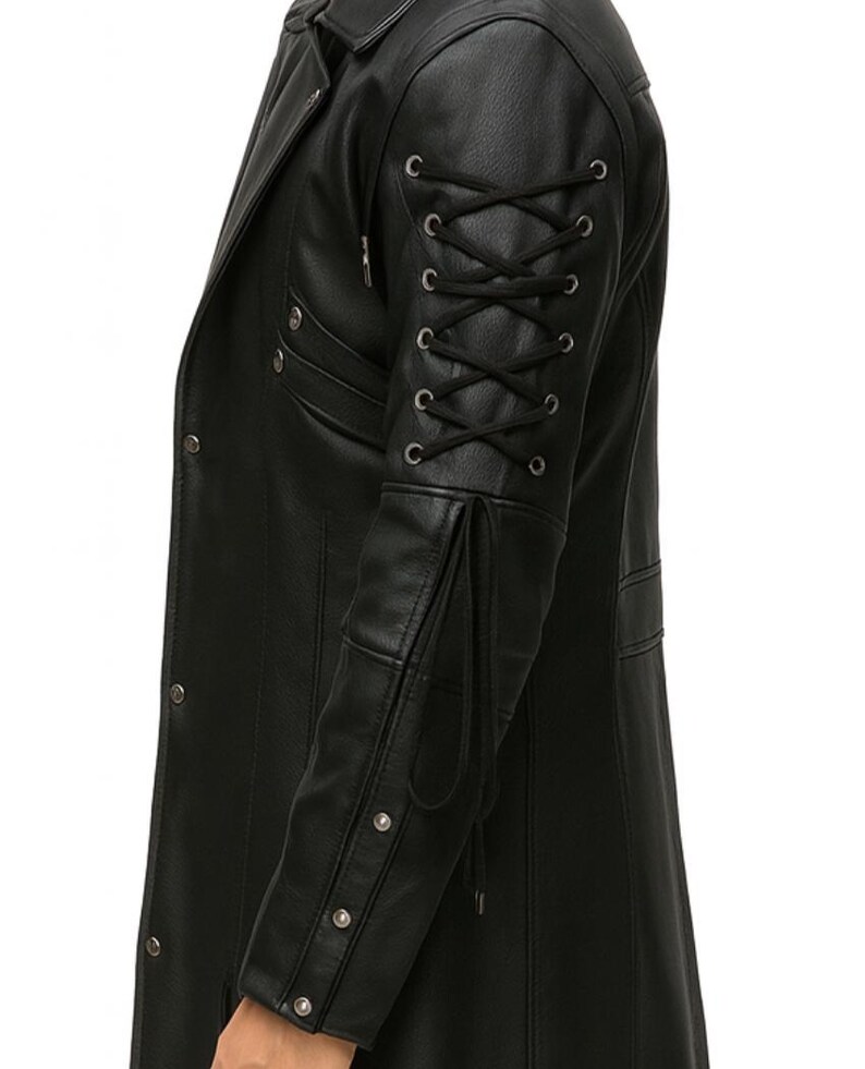 May include: A black jacket featuring a long sleeve with a lace-up detail consisting of black cord threaded through silver-toned metal eyelets. The sleeve also includes a series of silver-toned metal studs along the forearm and a long cord tie.