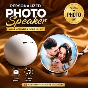 May include: A white, spherical photo speaker and a clear, round photo ornament with a couple's image. The speaker has a port and speaker holes. The ornament has a silver base and a beige and white cord. Text includes "PERSONALIZED PHOTO Speaker" and "YOUR MEMORIES, YOUR MUSIC."