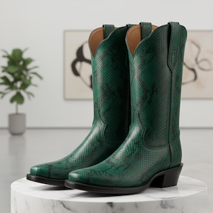 Może przedstawiać: Para zielonych butów kowbojskich ze wzorem skóry węża. Buty mają spiczasty nosek, obcas i wysoką cholewkę. Buty są wykonane ze skóry i mają klasyczny zachodni design.