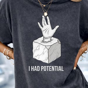 May include: A set of three ceramic mugs with a speckled, matte finish. The mugs are in shades of cream, light gray, and dark gray. Each mug has a simple, minimalist design and a rounded handle. The mugs are stacked on top of each other.