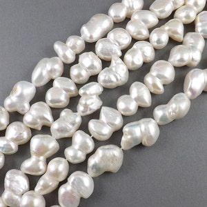 May include: A strand of white baroque pearls, each pearl is unique in shape and size. The pearls have an iridescent sheen and are strung on a white thread.