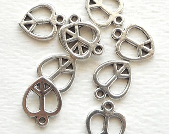 May include: A set of ten silver charm pendants shaped like hearts with a peace sign inside each heart. The charms have a loop at the top for attaching to a necklace or bracelet.