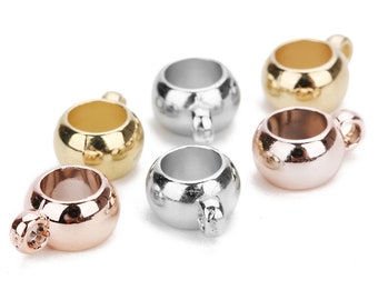 May include: Six metal ring charms in different finishes: gold, silver, rose gold, and a mix of silver and rose gold. The rings are round and have a small loop on one side.