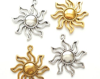 May include: Four sun charm pendants, two gold and two silver, with a detailed sun design. The charms are perfect for jewelry making or crafting.