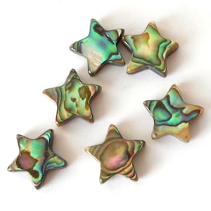 Peut inclure: Six perles en forme d'étoile en nacre d'ormeau irisée. Les perles sont d'un mélange de couleurs vertes, bleues et brunes.