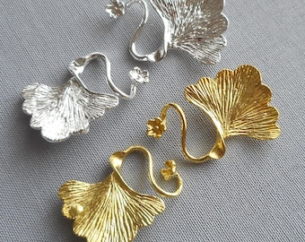 May include: Two pairs of ginkgo leaf shaped earring findings. One pair is silver and the other is gold.