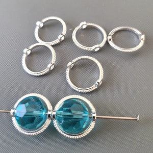 May include: Silver jump rings with clear rhinestones and two turquoise glass beads with silver accents.