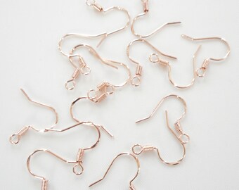 May include: A group of ten rose gold earring hooks. The hooks are made of metal and have a spring-loaded closure.