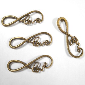 May include: Four antique gold-toned metal infinity symbol charms with the word "love" inscribed inside each charm.