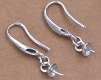 May include: A pair of silver earring hooks with a loop at the end for attaching a bead or charm. The hooks are made of metal and have a smooth, polished finish.