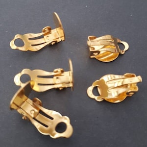 May include: Five gold-tone earring clips. The clips are designed to attach to earrings without pierced ears. The clips are made of metal and have a smooth finish.