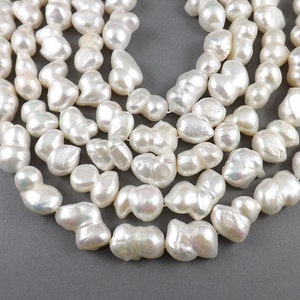 May include: A strand of white baroque pearls, with an iridescent sheen. The pearls are irregular in shape and size, and are strung on a clear thread.