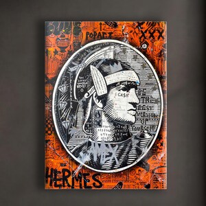 Könnte beinhalten: Ein gerahmtes Kunstwerk mit einem Schwarz-Weiß-Porträt in einem weißen Kreis auf orangefarbenem Hintergrund. Das Wort "HERMES" steht unten. Das Kunstwerk hängt an einer dunkelgrauen Wand über einem weißen Sofa mit braunen Kissen.