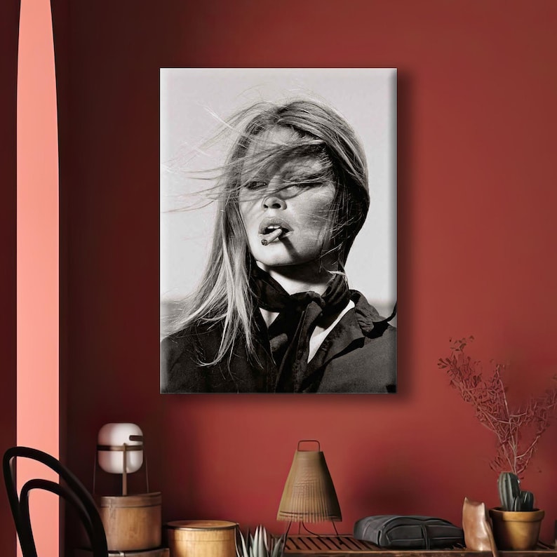 Puede incluir: Retrato en blanco y negro de una mujer con el pelo largo al viento, fumando un cigarrillo. Lleva una chaqueta oscura y una bufanda. La imagen es una impresi&oacute;n en lienzo.