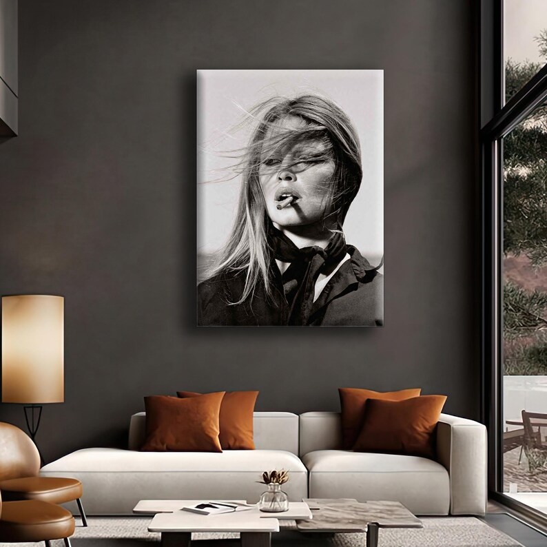 Puede incluir: Retrato en blanco y negro de una mujer con cabello largo y suelto, fumando un cigarrillo. Lleva una parte superior oscura y una bufanda. La imagen es una impresi&oacute;n en lienzo, colgada en un sal&oacute;n.