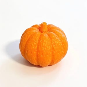 May include: A small, round, orange pumpkin-shaped object with a textured surface and a central stem. The pumpkin features vertical ridges and a vibrant, uniform orange colour throughout its exterior, creating a realistic representation of a gourd.