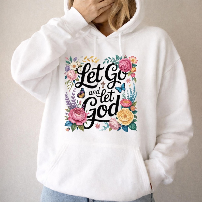 May include: A white hooded sweatshirt featuring a central graphic with the black text Let Go and let God, surrounded by colorful illustrations of pink, yellow, and red flowers, green leaves, a small brown cross, and two blue and orange butterflies.