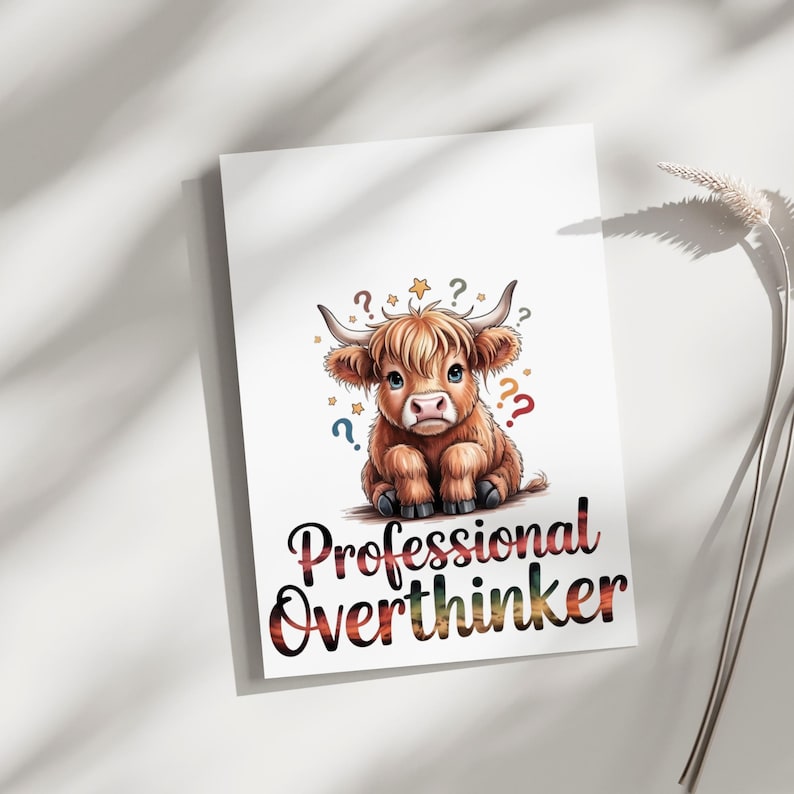 May include: A white rectangular print featuring a fluffy brown Highland cow illustration with small stars and colorful question marks surrounding its head. Below the cow, the text Professional Overthinker is written in a bold, dark font.