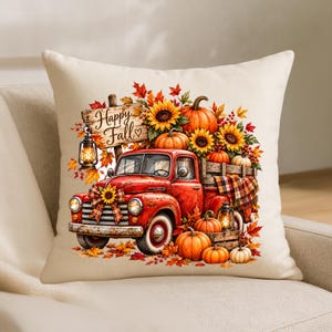 May include: A cream-colored throw pillow featuring a graphic of a red vintage truck loaded with pumpkins, sunflowers, and autumn leaves. A wooden sign hanging from a lantern reads Happy Fall. The design includes plaid accents and rustic lanterns.