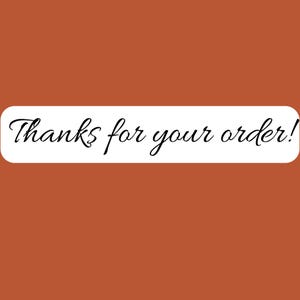 May include: A rectangular white banner with rounded corners displays the text "Thanks for your order!" in elegant black cursive script. The banner is set against a solid, warm, reddish-brown background.