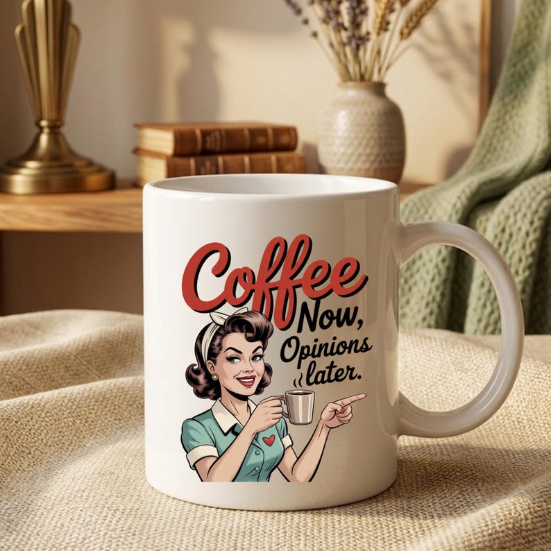 May include: White ceramic coffee mug featuring a retro illustration of a woman holding a coffee cup. The mug has the words "Coffee Now, Opinions later" in red and black lettering. The woman is wearing a blue dress and a white headband.
