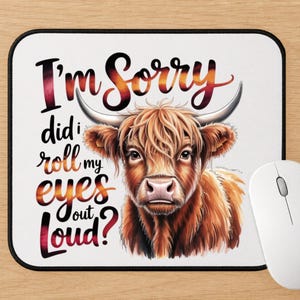 May include: A rectangular mouse pad with a white background featuring a brown Highland cow illustration and the text I'm Sorry did i roll my eyes out Loud? in a gradient orange and red font. The mouse pad has a black border and rounded corners.