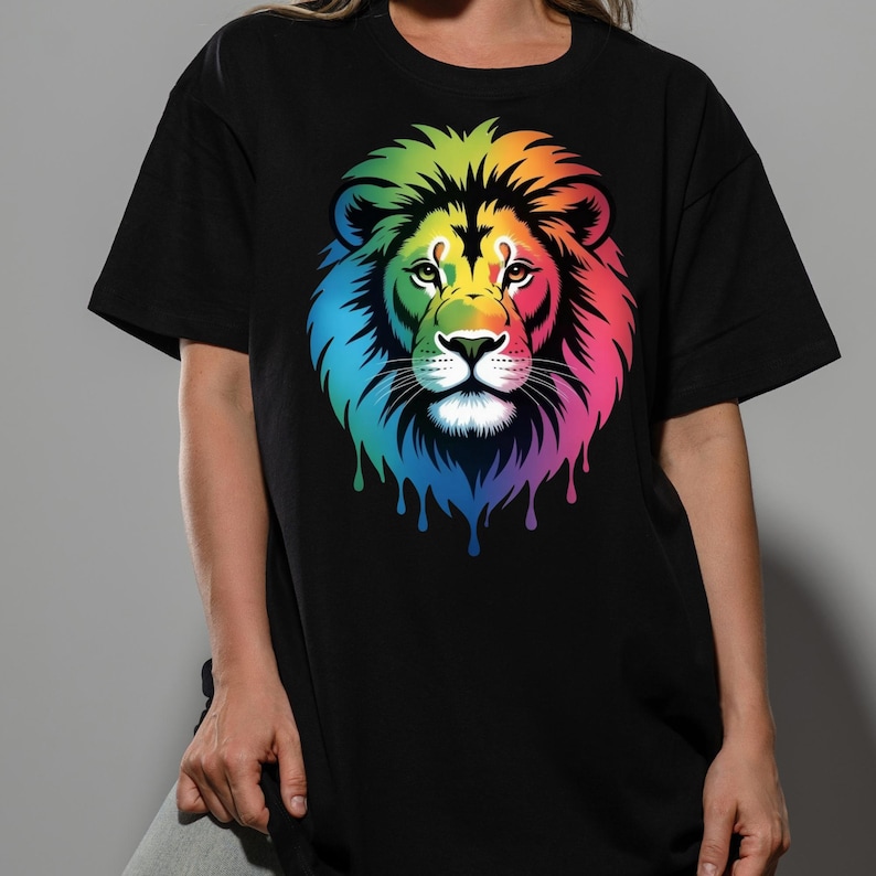 May include: Black t-shirt featuring a colorful lion graphic. The lion's mane is a vibrant rainbow of colors, with the design dripping down the shirt. The lion's face is detailed with a white muzzle and brown eyes.