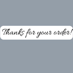 May include: A rectangular white sticker with rounded corners featuring the black cursive text Thanks for your order! printed in the centre. The sticker has a clean, simple design with a smooth finish and clear, legible lettering for customer communication.