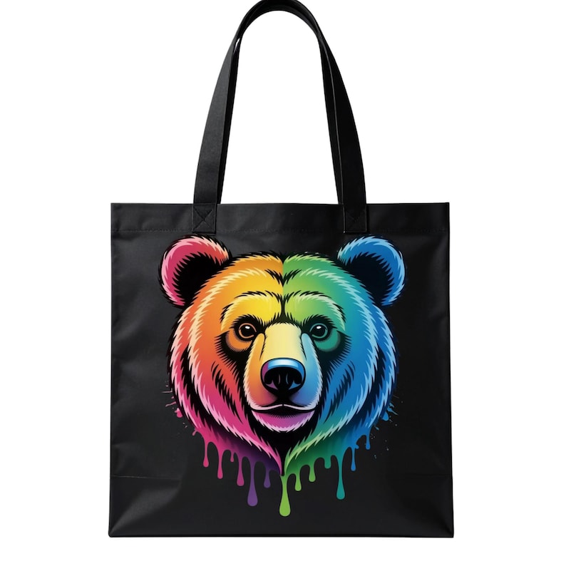 May include: Black tote bag featuring a colorful bear face design. The bear's head is split into rainbow colors, with dripping paint effects. The bag has black handles for carrying.