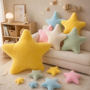 May include: A selection of star-shaped cushions in pastel shades such as yellow, blue, pink, and green. The cushions are displayed on a white sofa and a cream rug, creating a soft, inviting look. Smaller star cushions are also scattered around the scene.
