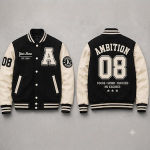 May include: A black and cream varsity jacket featuring a front letter A, the text Your Name EST. 2024, and the number 08. The back displays the text AMBITION 08, FOCUS GRIND SUCCEED NO EXCUSES, and three stars. It has striped ribbed trim.