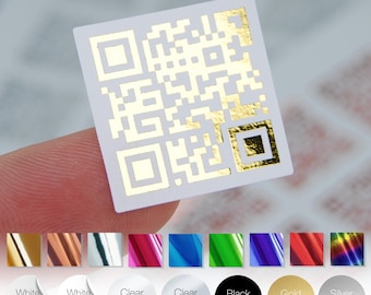 May include: A small, square white sticker with a gold QR code design. The sticker is held between fingers, with a selection of color options below, including white matte, white gloss, clear gloss, clear matte, black stickers, gold matte, and silver matte.