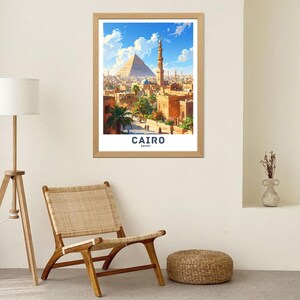 Może przedstawiać: Oprawiony wydruk przedstawiający Kair, Egipt, z Wielką Piramidą i minaretem na tle błękitnego nieba. Wydruk zawiera słowa "CAIRO" i "EGYPT" w białym tekście. Rama jest jasnobrązowa.