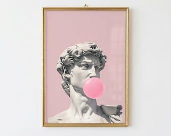 May include: A framed print showing a classical bust of David with a bubblegum bubble. The sculpture is white, set against a pink background, and framed in gold. The bubblegum is a bright pink colour.