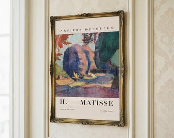 May include: A framed art print of an abstract landscape by H. Matisse, titled "Papiers Découpés". The print is in a gold ornate frame. The wall behind the print has a floral pattern.