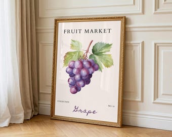 May include: A framed print with a watercolour illustration of a bunch of purple grapes and green leaves. The text "FRUIT MARKET" is at the top, with "Grape" in cursive below. The frame is gold-coloured.