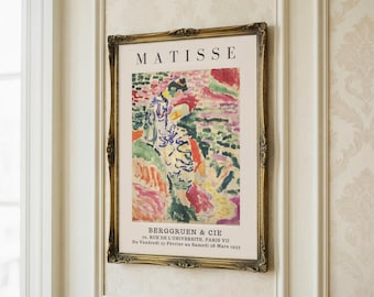 May include: A framed art print of a Matisse painting, displayed in a gold ornate frame. The print features the artist's name, "MATISSE", and gallery details. The artwork is an abstract composition with a variety of bright colours.