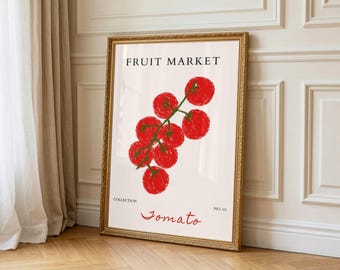 May include: A framed art print displaying a bunch of red tomatoes on a green stem against a cream backdrop. The words "FRUIT MARKET" are at the top, with "Tomato" in cursive below. The frame is gold.