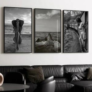 Può includere: Set di tre stampe artistiche incorniciate in bianco e nero. Le stampe raffigurano scene di una persona su una spiaggia, in acqua e su un treno. L'arte è esposta sopra un divano in pelle nera.