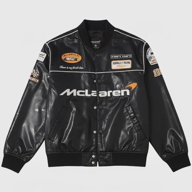 May include: Black McLaren racing jacket with white accents and multiple patches. The jacket features the McLaren logo and the text "There is no finish line." The jacket has a classic bomber style with a ribbed collar and cuffs.