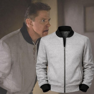 May include: A light gray bomber jacket with a black collar, cuffs, and zipper. The jacket has a classic design, with a full-length zipper and a tailored fit. The jacket is made of a soft, textured material.