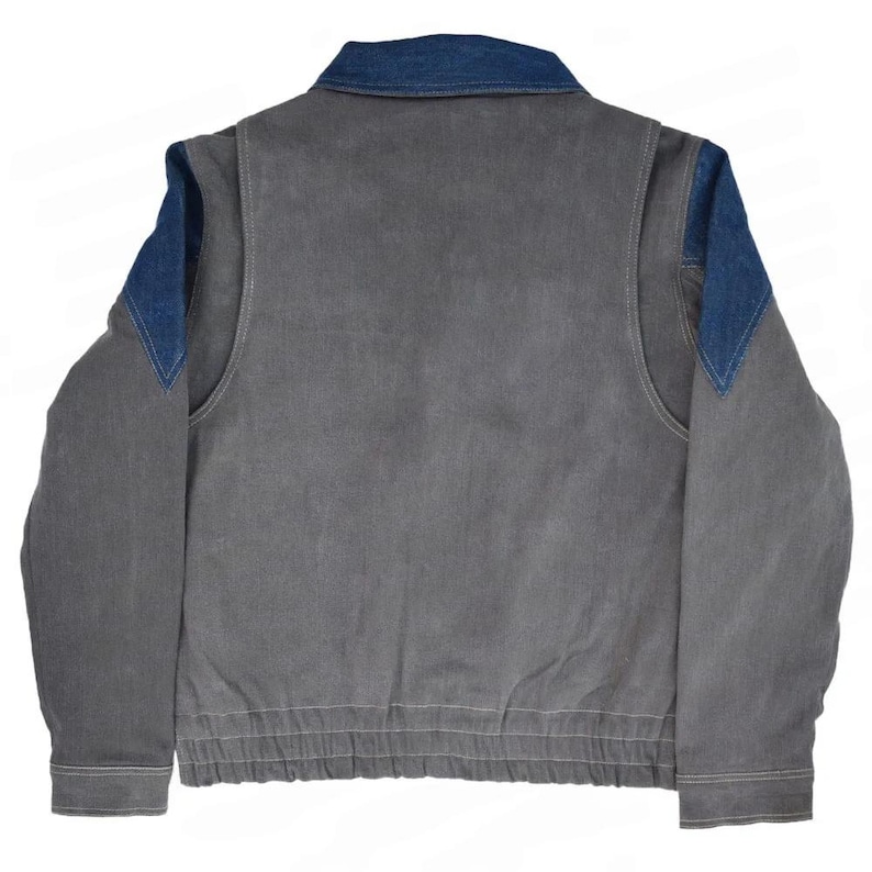 May include: A gray jacket with a denim collar and denim shoulder accents. The jacket has a ribbed hem and cuffs, and a zipper closure. The back of the jacket is visible in the image.