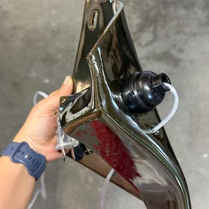 Peut inclure: Une applique murale en c&eacute;ramique brun fonc&eacute; brillant avec une forme sculpturale pli&eacute;e. Le luminaire pr&eacute;sente une douille noire circulaire mont&eacute;e sur le devant, un cordon &eacute;lectrique transparent et une fiche &agrave; deux broches. La surface est r&eacute;fl&eacute;chissante.
