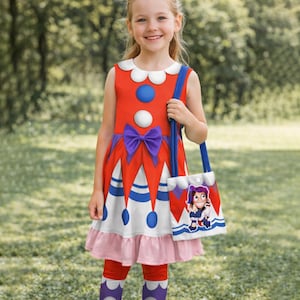 Könnte beinhalten: Ein rot-weißes Kleid im Clown-Stil mit einer lila Schleife, blauen und weißen Akzenten und einer passenden Tragetasche. Das Kleid hat einen weißen Kragen und einen rosa Rock. Die Tragetasche hat einen blauen Riemen und eine Cartoonfigur auf der Vorderseite.