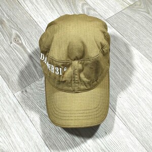 May include: A tan-colored military-style cap featuring a grid-like ripstop fabric pattern. The front panel displays the white embroidered text DANGER 31. The cap has a flat top, a structured crown, and a curved brim with visible horizontal stitching.