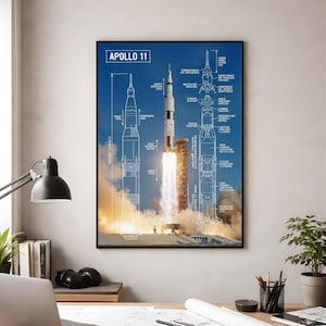 Könnte beinhalten: Ein gerahmtes Poster mit dem Start von Apollo 11. Das Poster zeigt ein detailliertes Diagramm der Saturn V-Rakete mit dem Text "Apollo 11" oben. Die Rakete wird in verschiedenen Flugphasen vor blauem Himmel dargestellt.